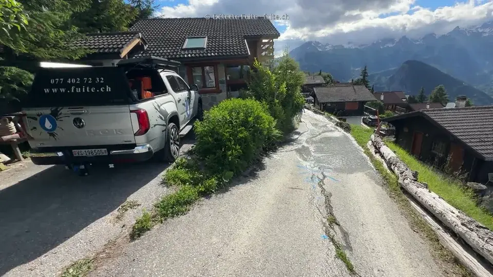 Pick-up Détecte Fuite et marquage bleu sur une route entre des chalets